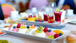Un assortiment de desserts légers et colorés, comme des fruits frais, des yaourts et des mousses, présentés de manière appétissante sur une table.
